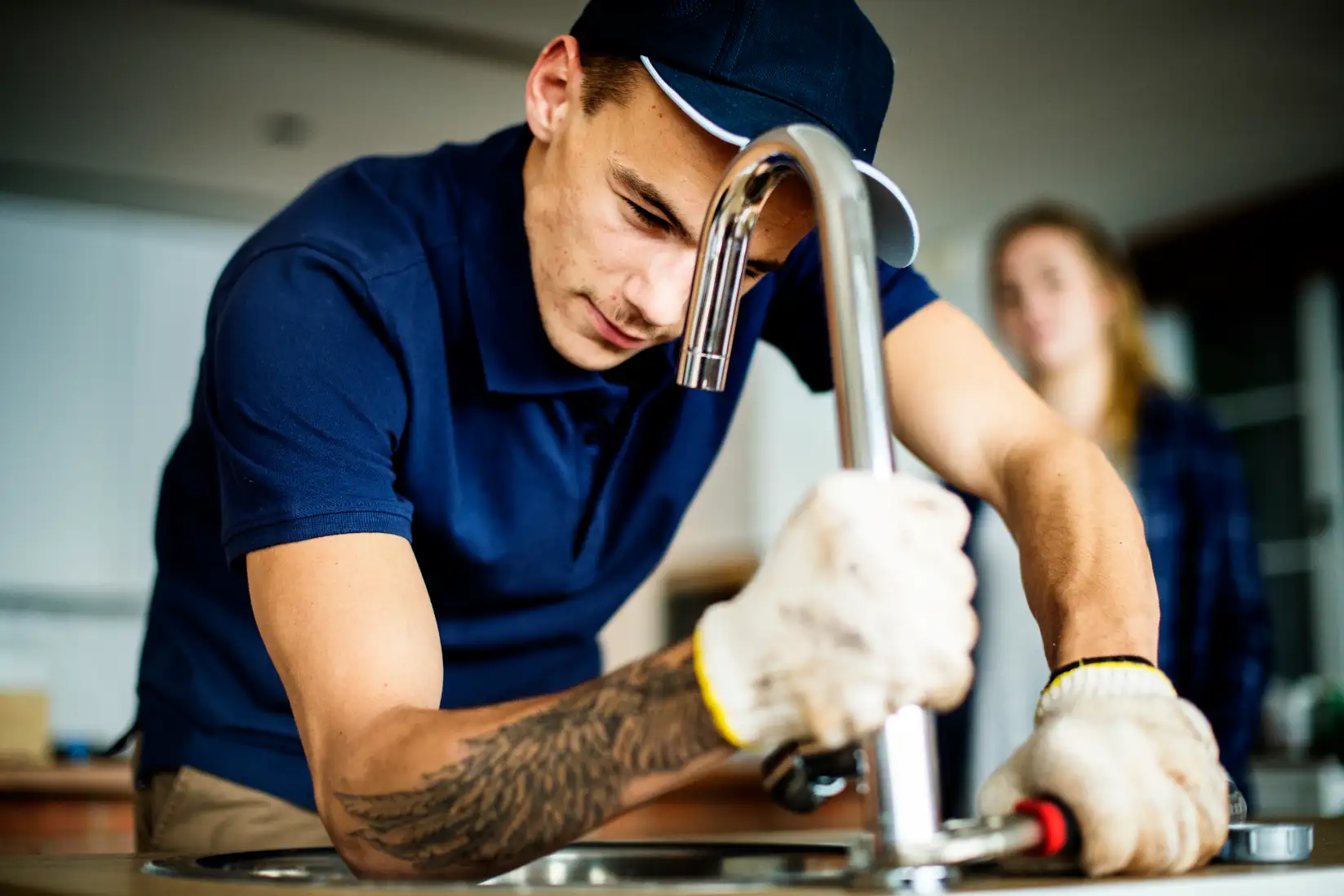 Plumber working on a chrome kitchen tap